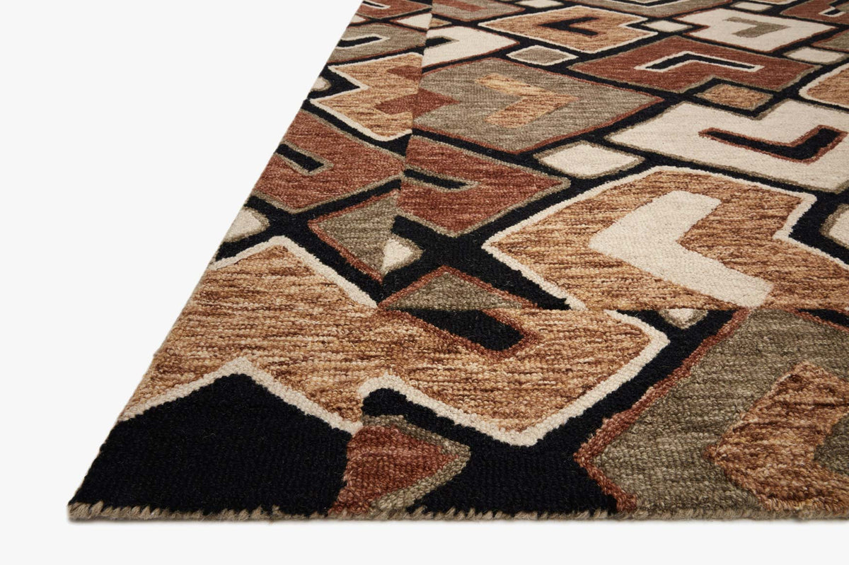 Hand-tufted rug corner showing geometric pattern in sage, tan, bark, and black