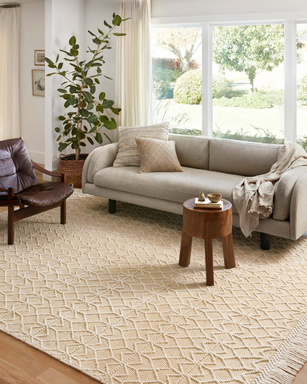 Ivory geometric rug with fringe trim on floor