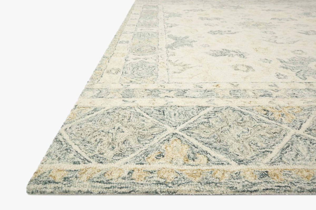 Hooked rug corner view with geometric-and-floral pattern in ivory and slate tones