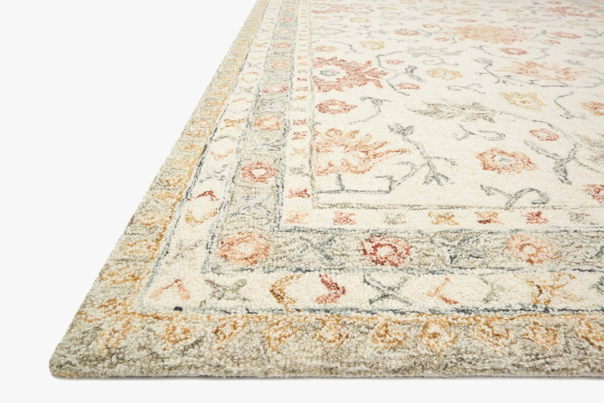 Ivory hooked rug angled view with rust and pastel botanical pattern, textured pile