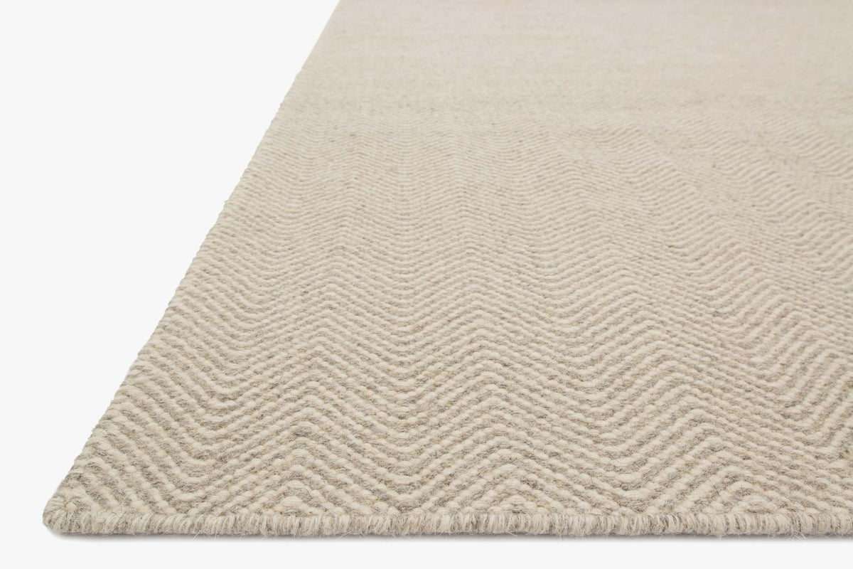 Hand-woven rug corner in light gravel beige with tight wavy loop texture