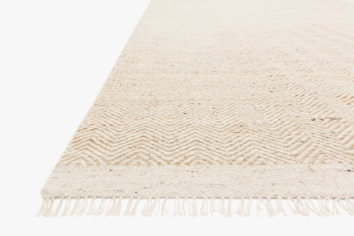 Natural rug with subtle chevron pattern and fringe border at edge