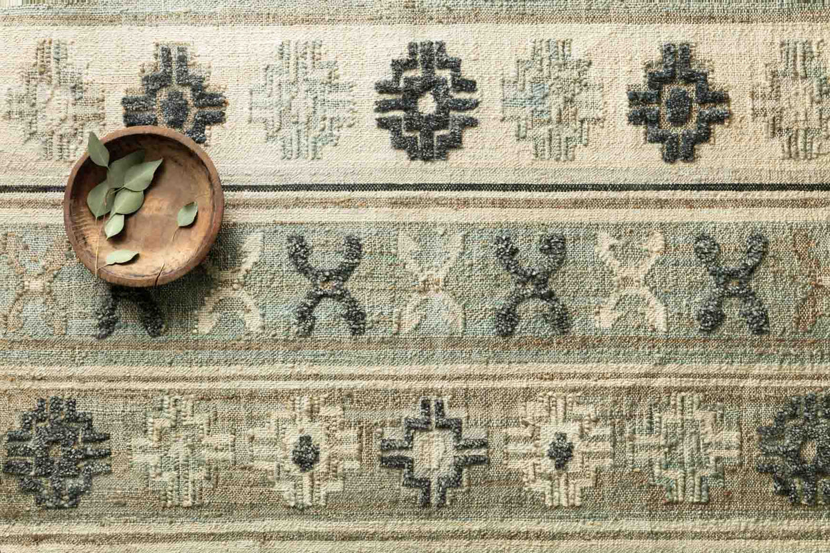 Hand-woven rug close-up with aqua ground and dark navy cross and plus geometric pattern