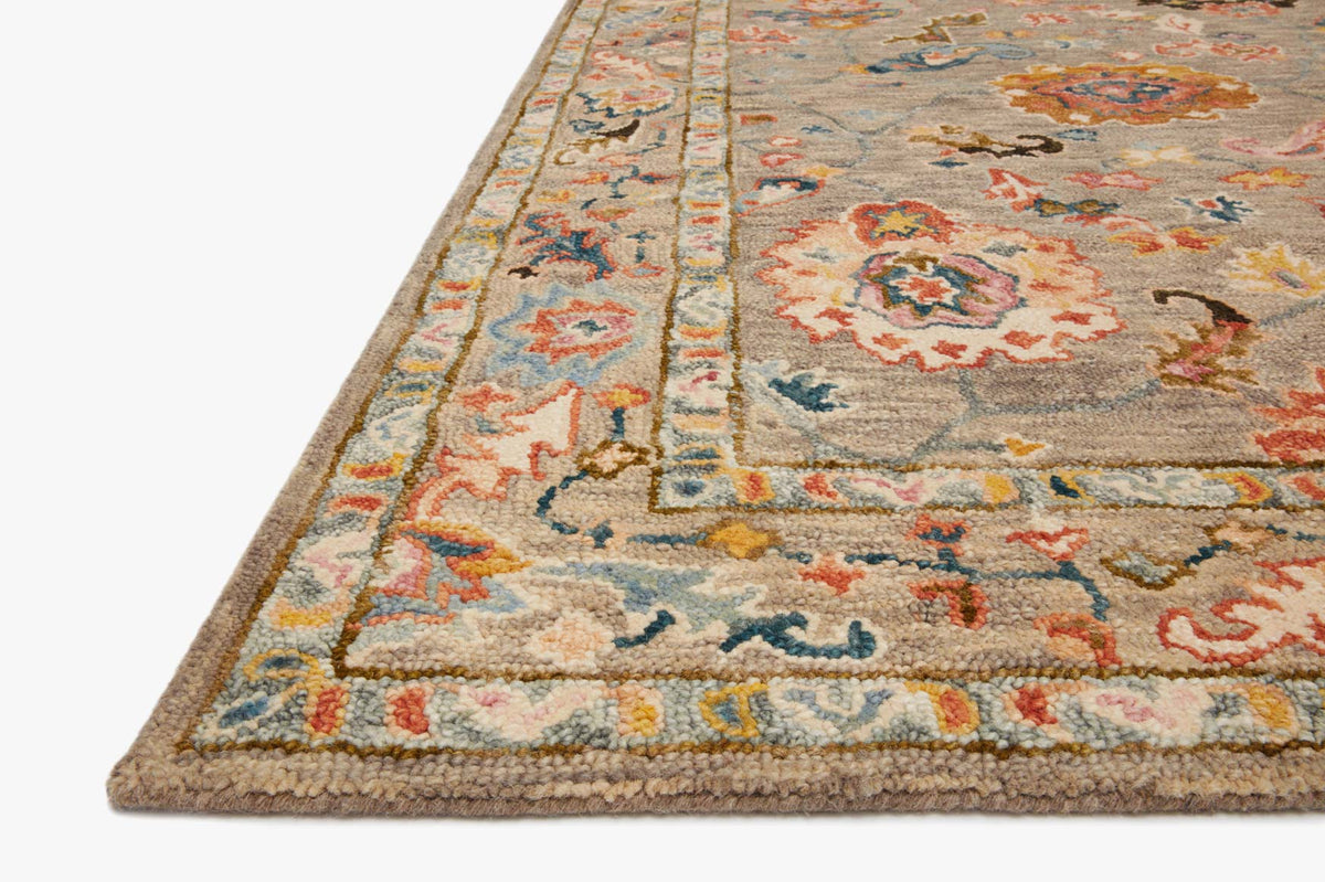 Grey hooked rug corner with multicolor floral medallion pattern and flat woven edge