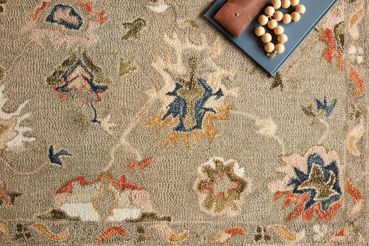 Close-up of grey hooked rug texture with colorful floral and medallion shapes