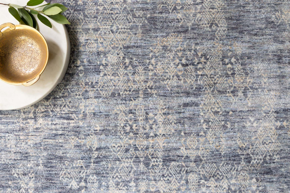 Dark blue and light blue abstract rug with woven texture and geometric distress pattern.