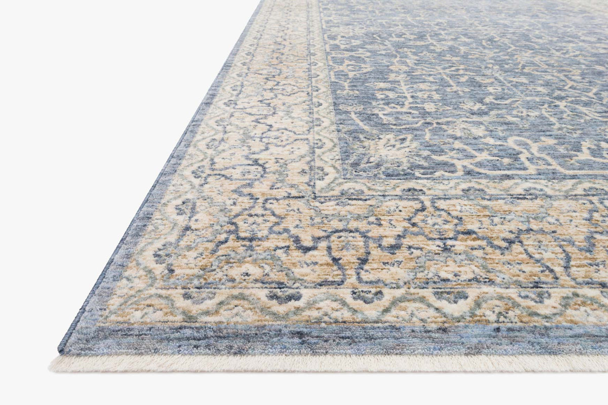 Angled traditional power-loomed rug with blue and ivory distressed geometric motifs