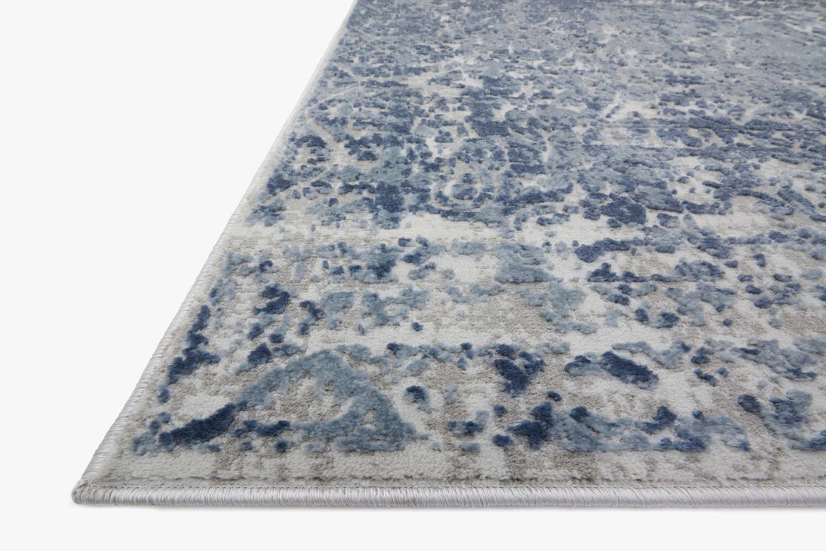 Blue and stone abstract power-loomed rug corner with distressed texture on flat weave