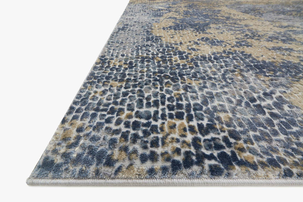 Power loomed rug corner view, ocean-blue base with gold-toned mottled texture
