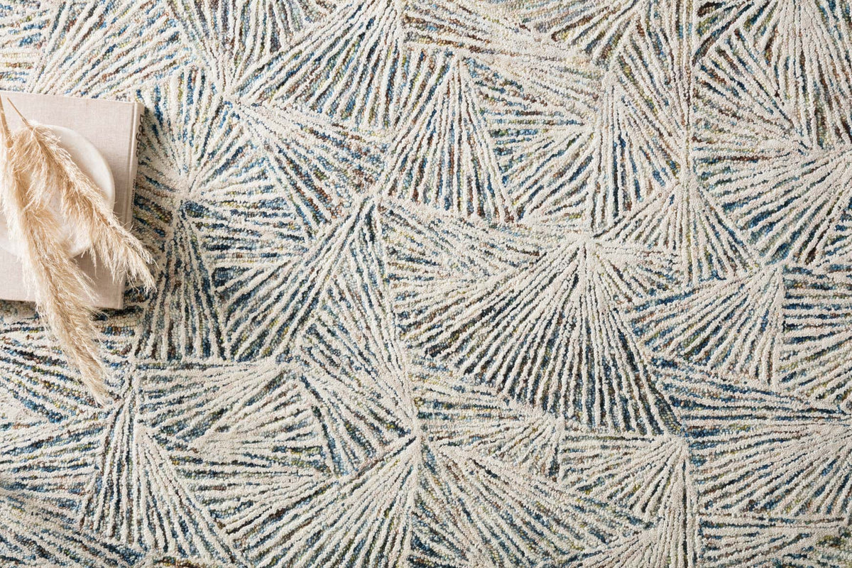 Hand-tufted rug close-up: beige ground with blue lagoon radiating line texture