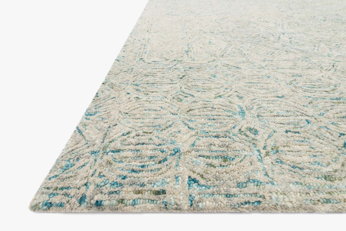 Aqua-and-cream hand-tufted rug corner detail with wavy abstract texture