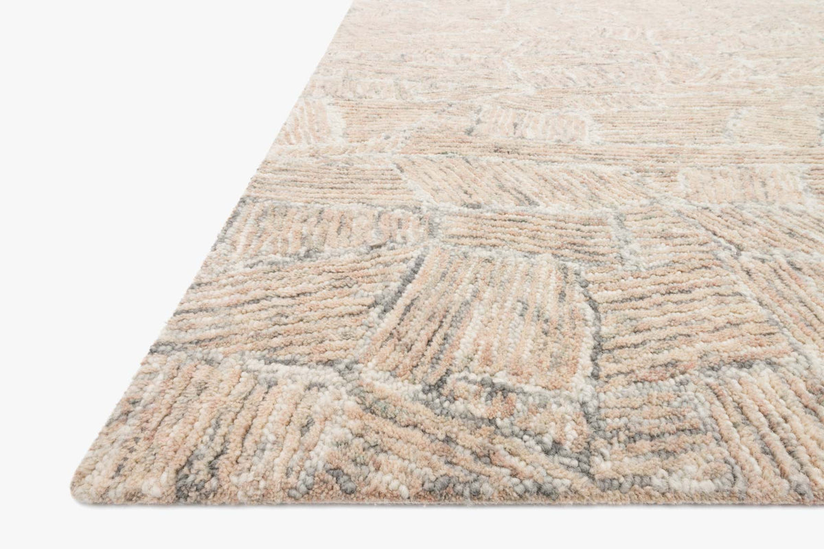 Blush hand-tufted rug corner with dense looped texture and geometric motif