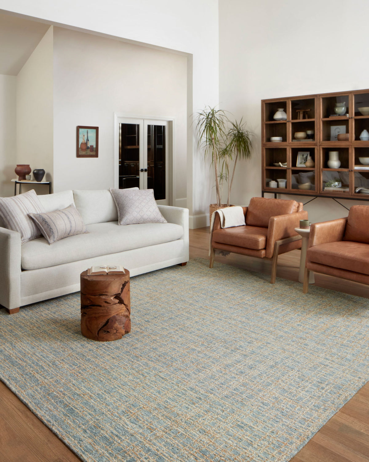 Blue and sand area rug laid in a living room, showing its dense grid texture.