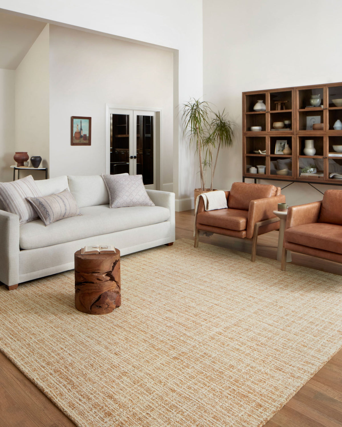 Contemporary straw-and-ivory hand-tufted rug, flat weave texture in a living room setting.