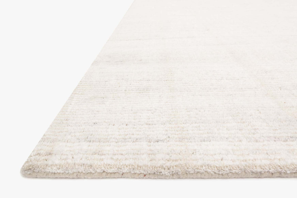 Ivory transitional hand loomed rug corner with textured pile and subtle woven stripes