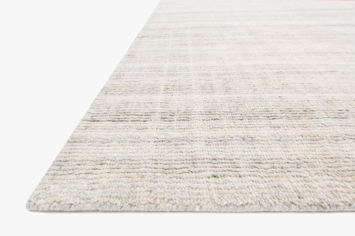 Silver hand-loomed rug with textured horizontal bands and visible short pile edge