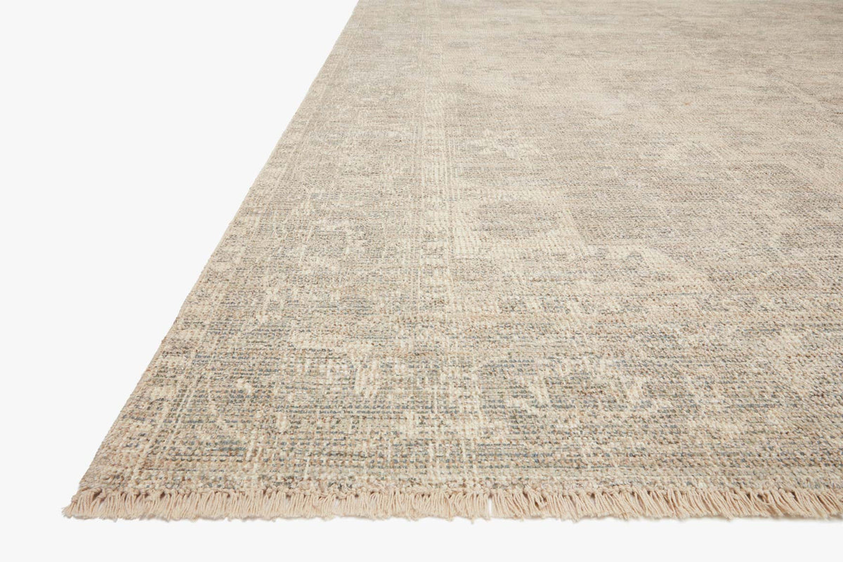 Ivory-and-grey handwoven rug corner with short fringe along the edges