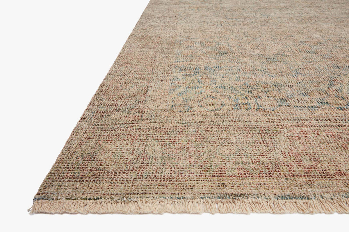 Transitional hand-woven rug corner in denim blue and rust with short fringed edge