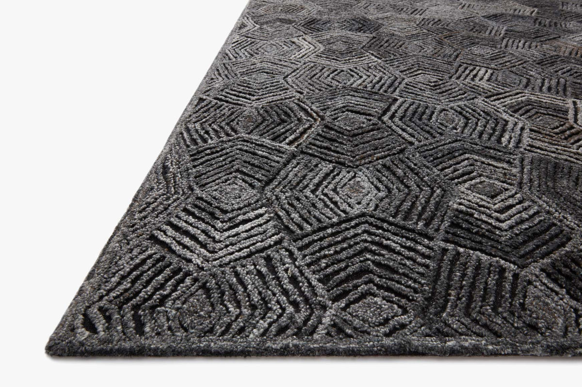 Charcoal geometric hooked rug corner with diamond and zigzag pattern, textured pile