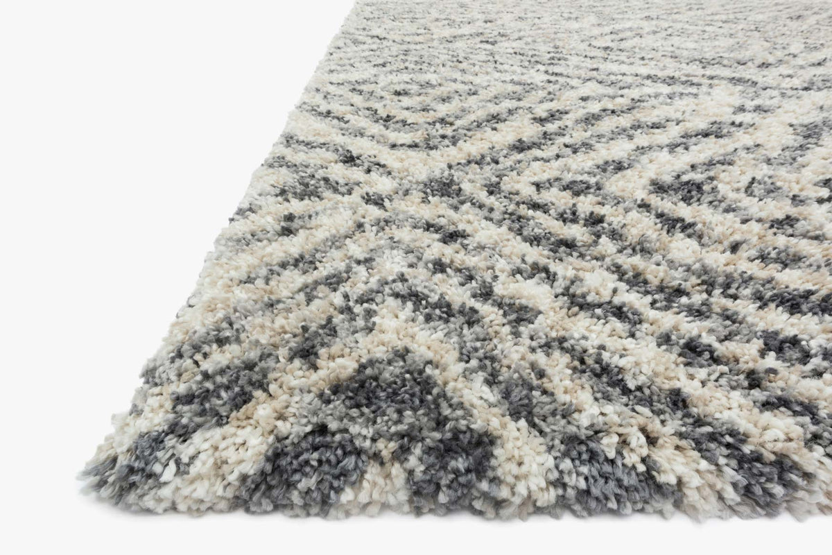 Shag rug corner close-up showing thick textured pile in graphite and sand