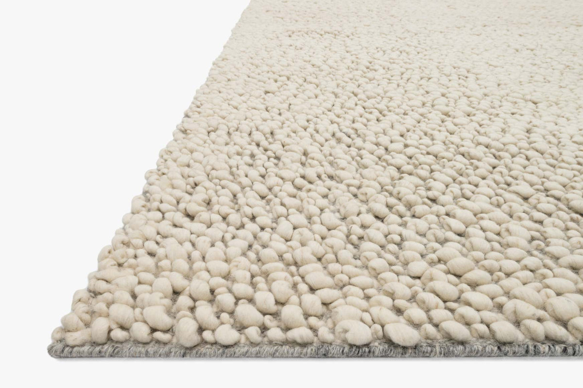Ivory rug corner close-up with thick tufted loops and soft pile texture