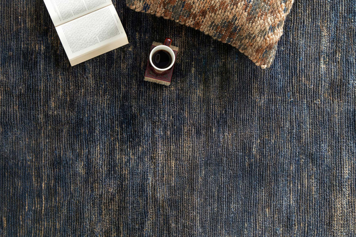 Indigo rug surface with vertical texture lines and mottled abstract pattern