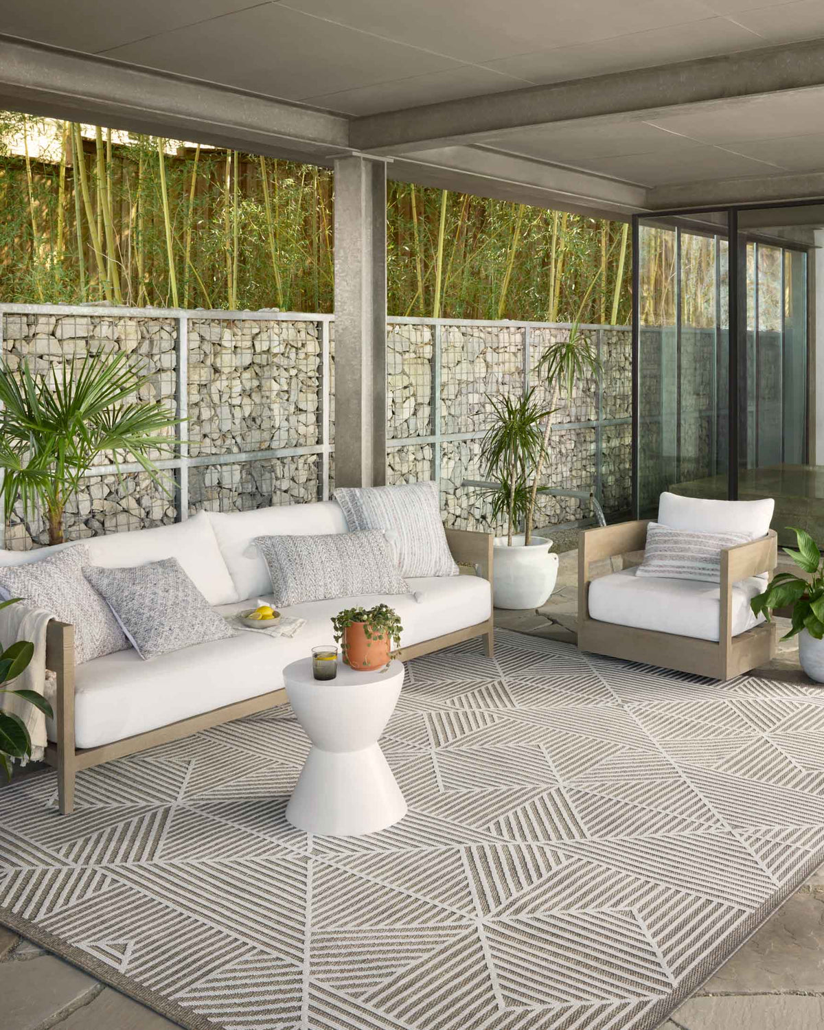 Indoor/outdoor power-loomed rug in ivory and taupe with repeating geometric medallion