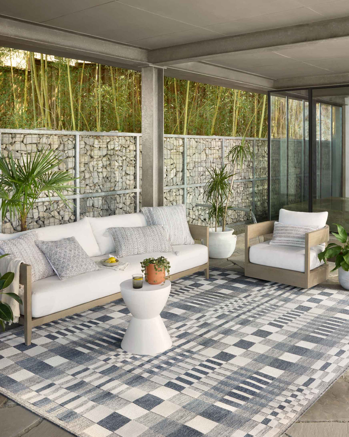 Indoor/outdoor power-loomed rug with patchwork checks in ivory, denim, and gray.
