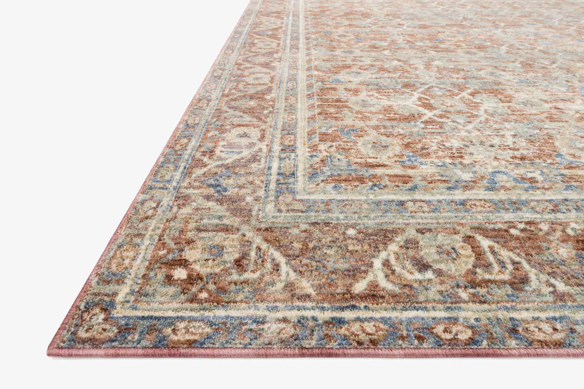 Traditional power loomed rug corner with distressed border and medallion in terracotta and teal