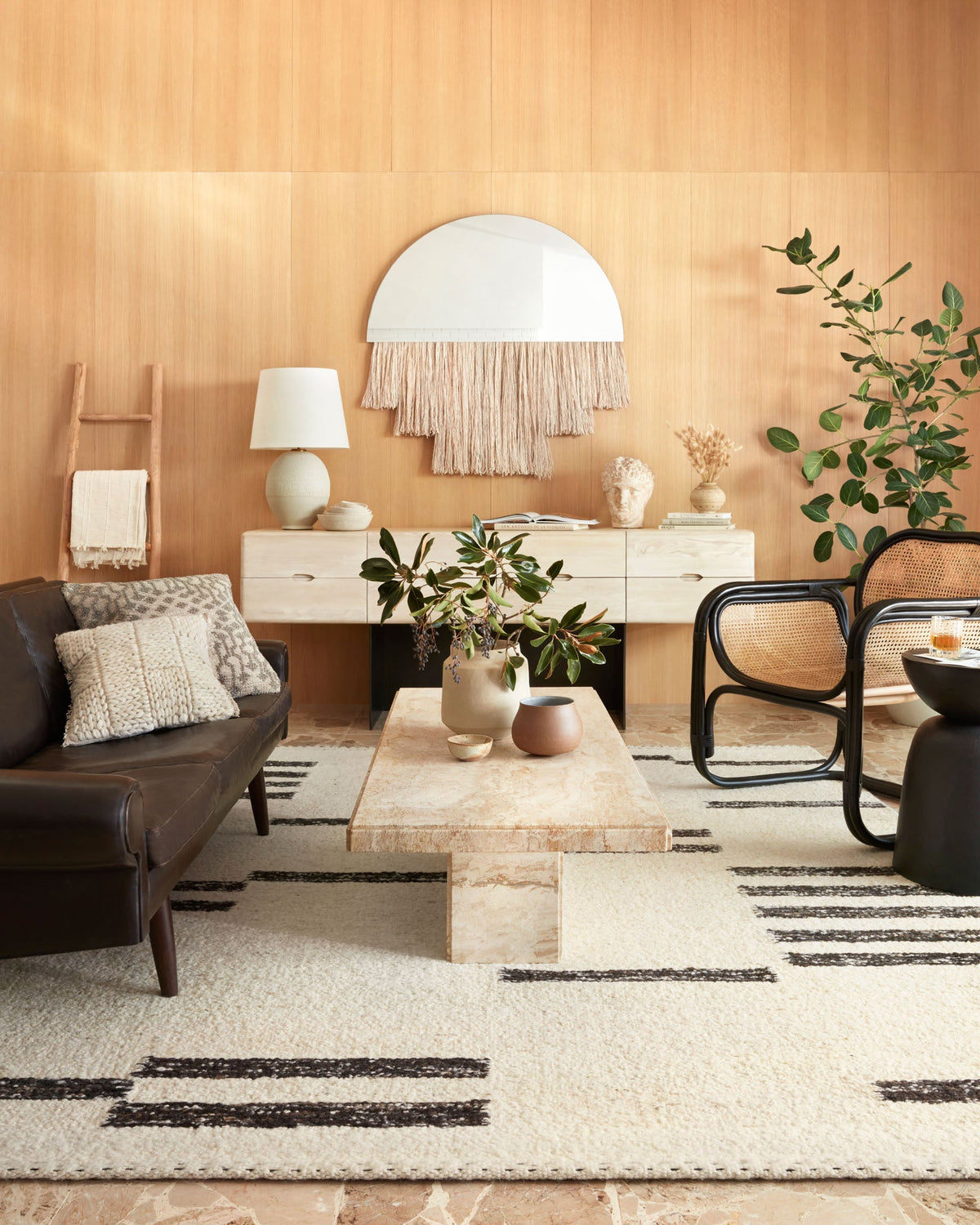 Geometric natural rug with dark stripe accents laid in a living room setting