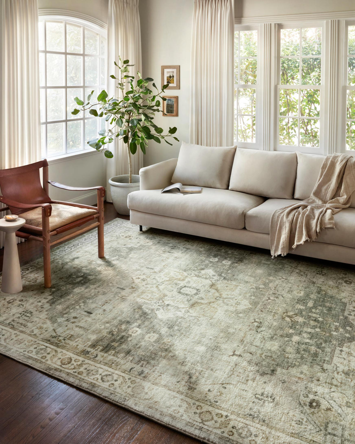 Sage and beige traditional rug with distressed motifs and ornate border.