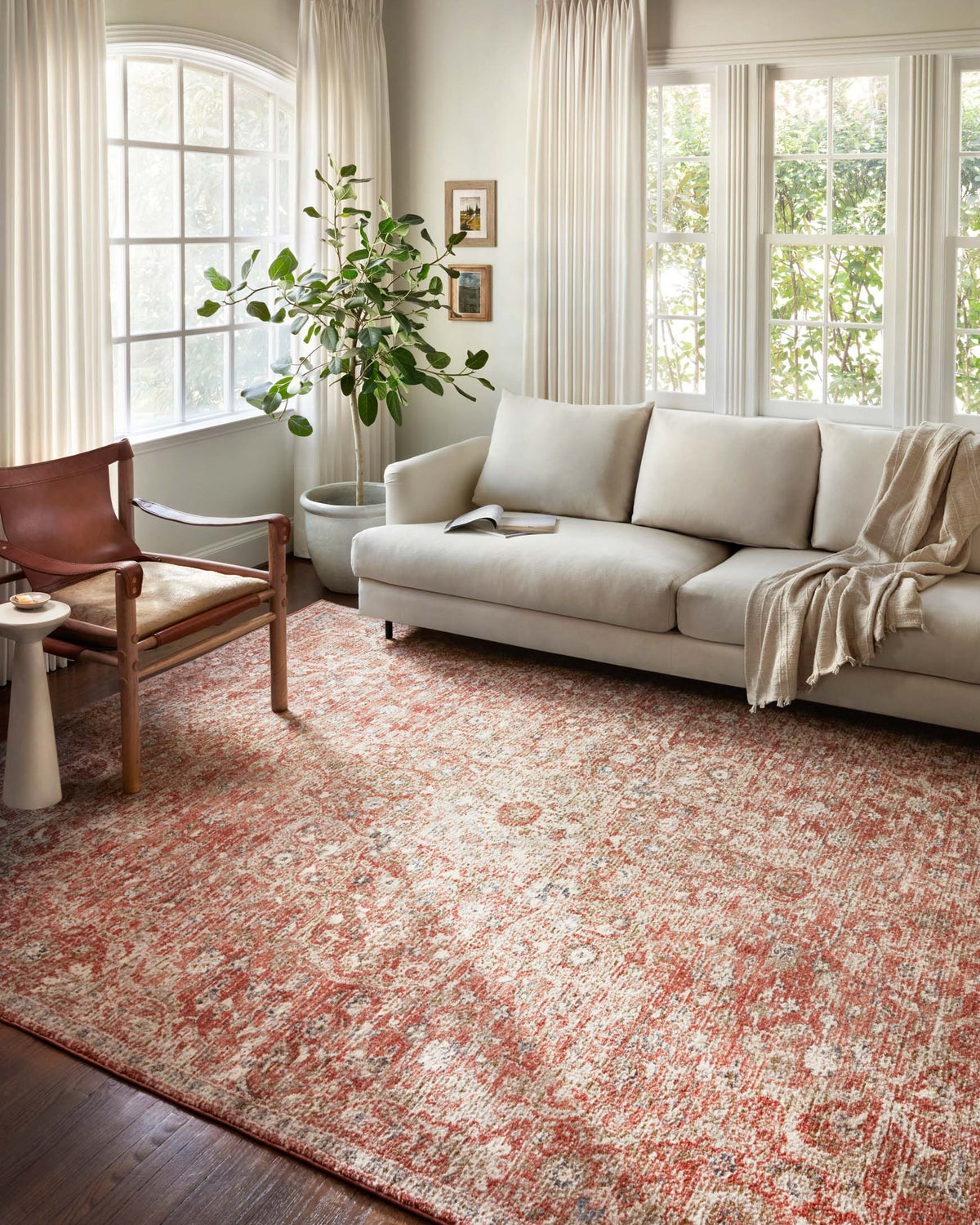 Rust and beige area rug with traditional medallion motif on hardwood floor