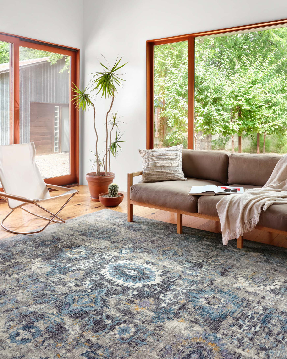 Grey patterned area rug with blue and gold distressed geometric motifs