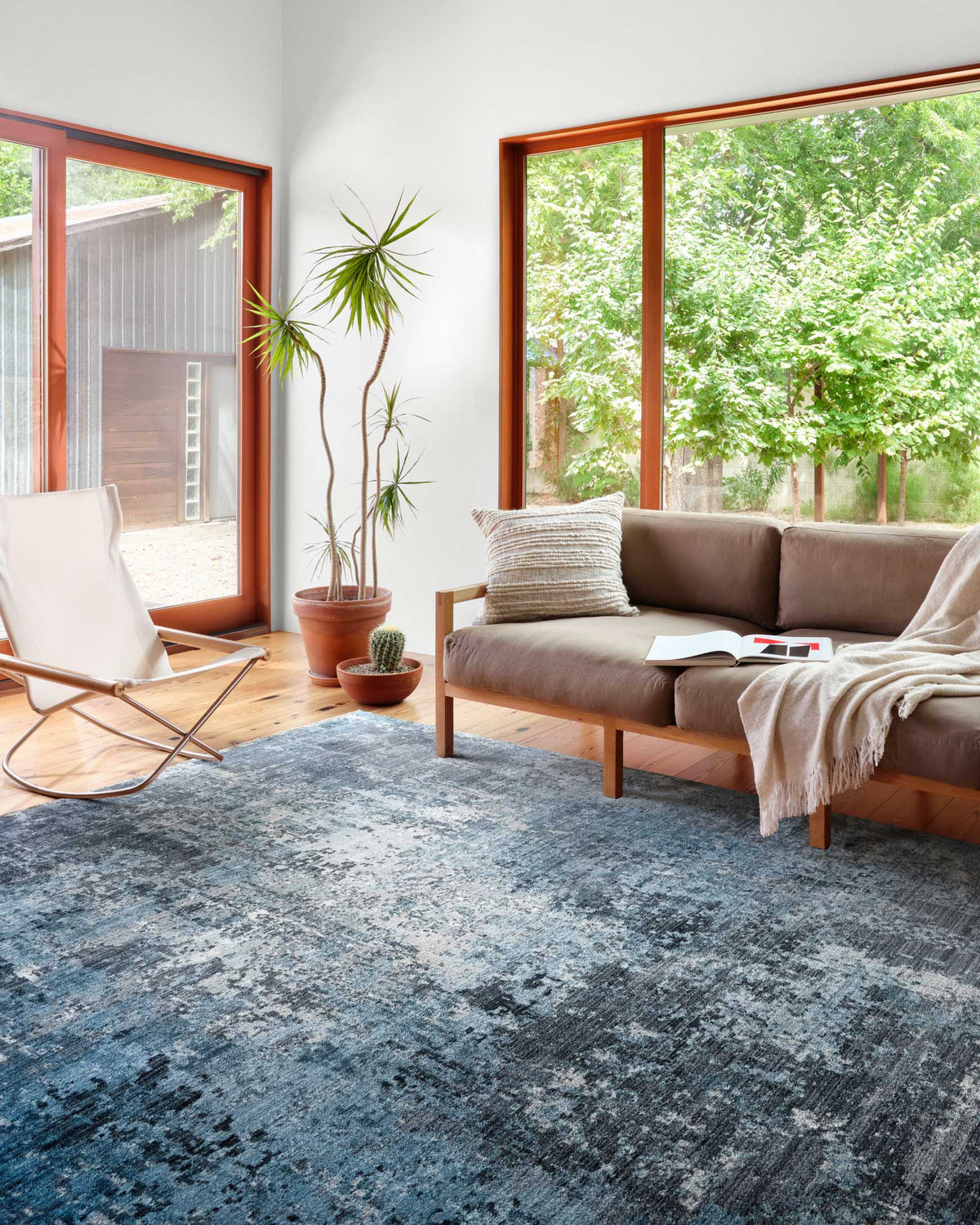 Charcoal-and-sky abstract rug with distressed texture, flat weave look