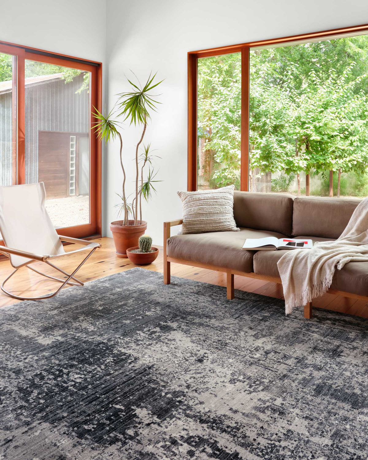 Charcoal and silver abstract rug with distressed detailing in a living room setting