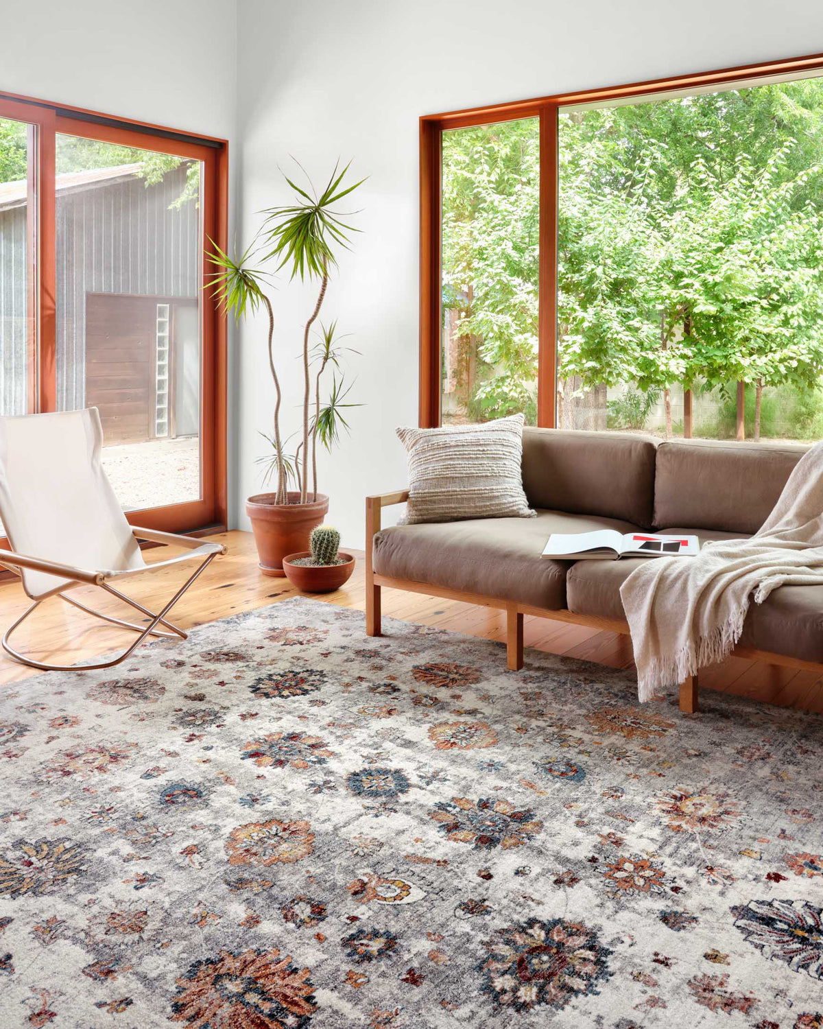Ivory patterned area rug with multicolor floral medallions, laid on hardwood flooring.