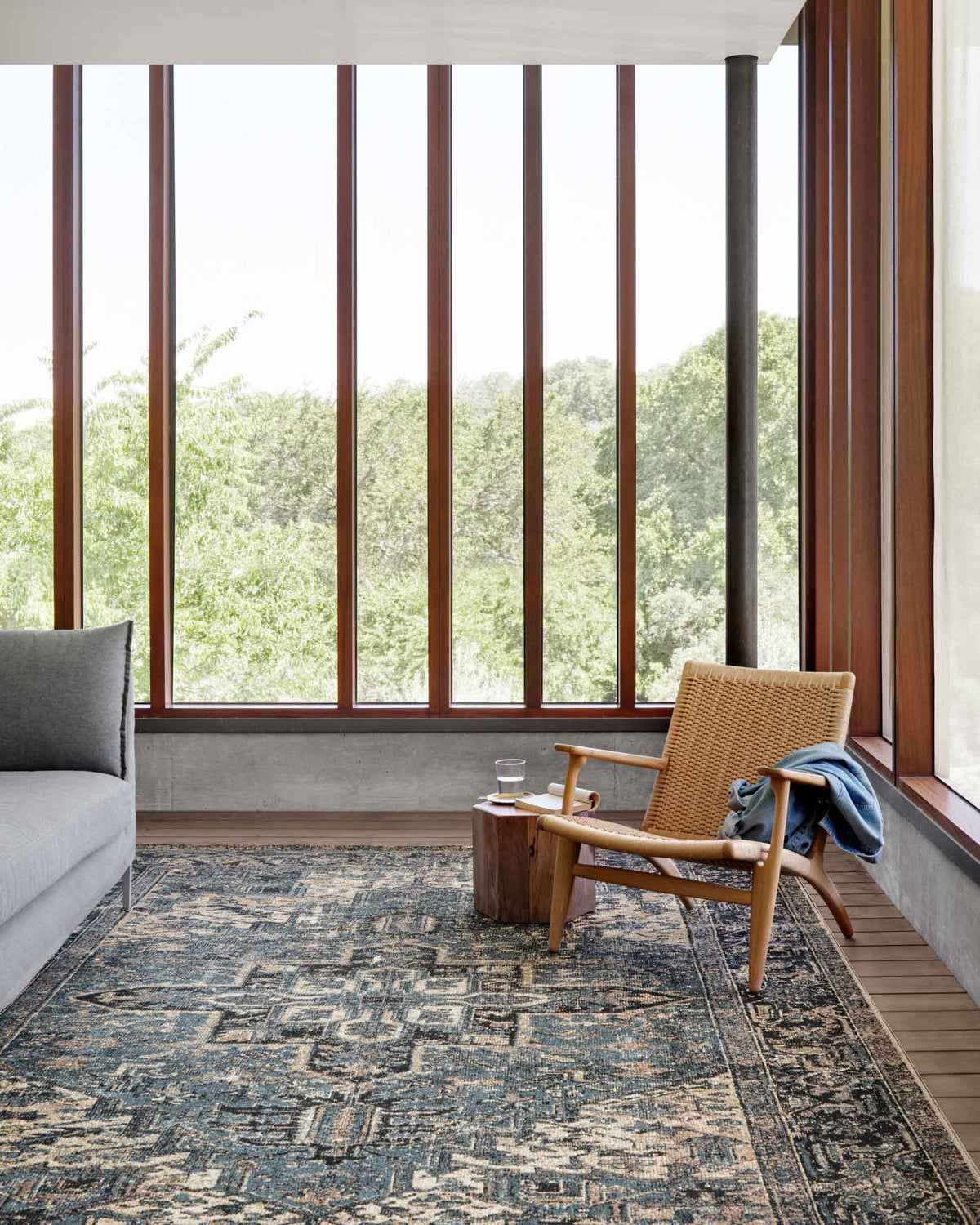 Blue and dark navy traditional rug with geometric medallion pattern, shown in a living room