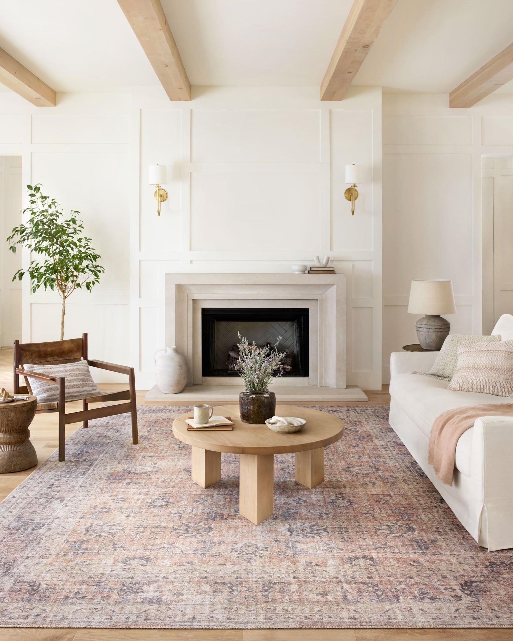 Blush and grey area rug with distressed pattern under living room furniture.
