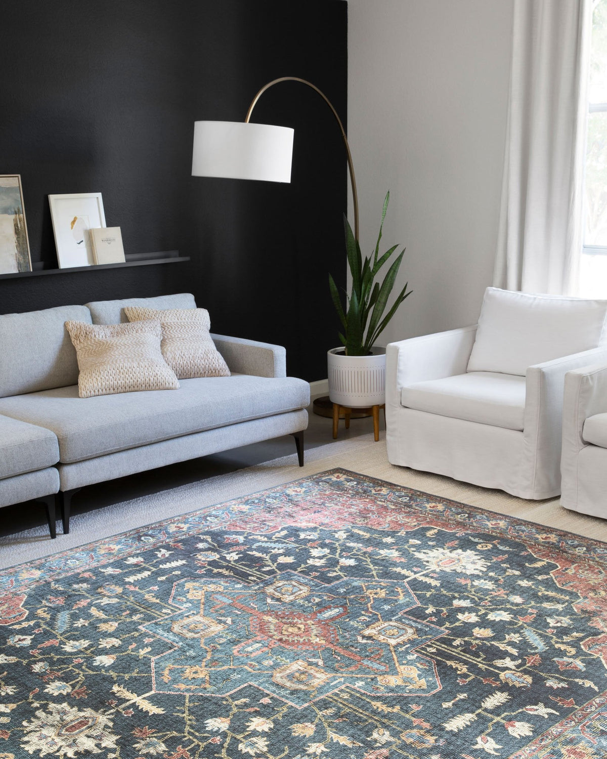 Traditional power-loomed rug on floor with denim blue, brick red, and cream geometric motifs