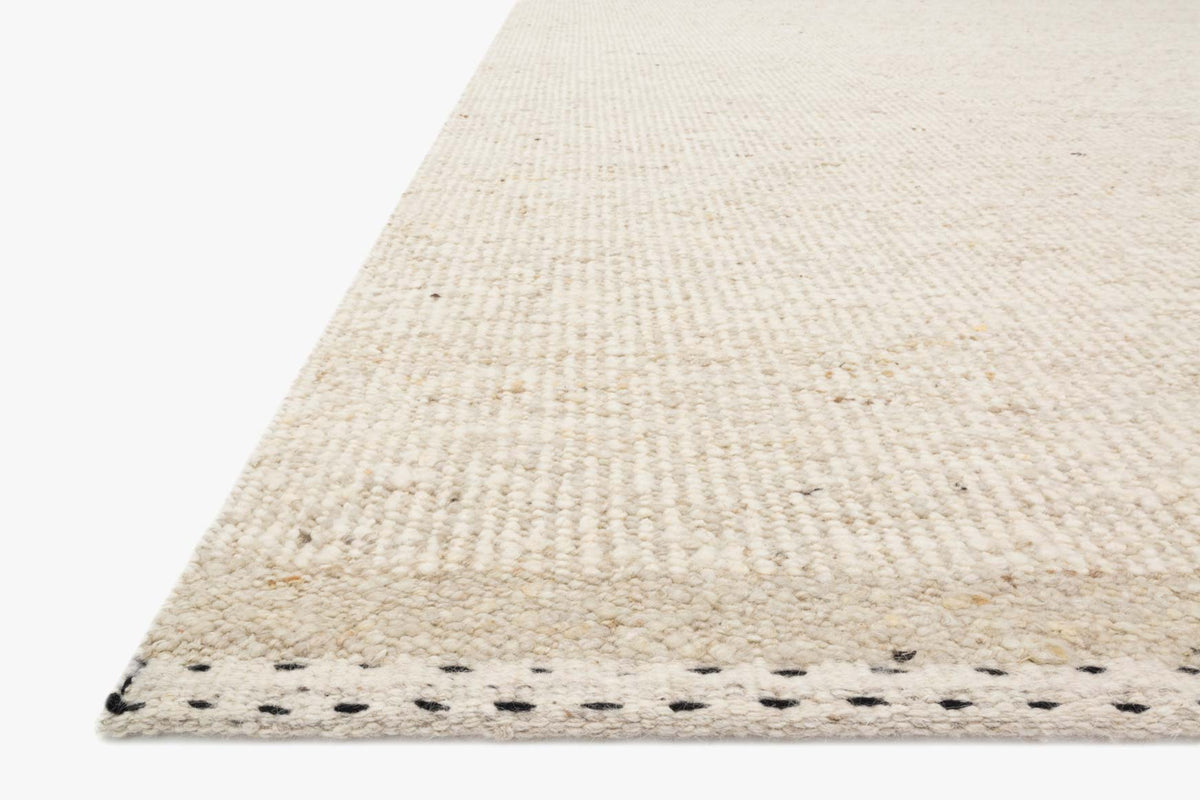 Oatmeal hand-woven rug with textured low-pile surface and stitched edge border