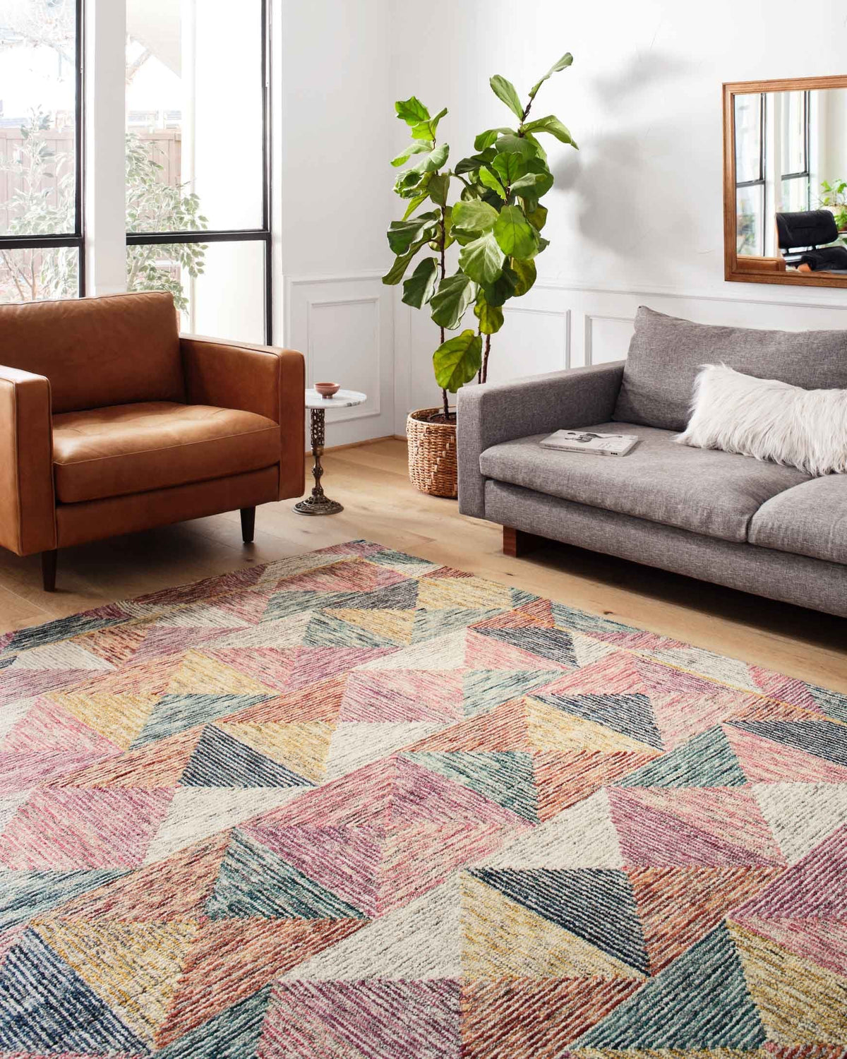 Multicolor geometric hooked area rug laid on a wood floor