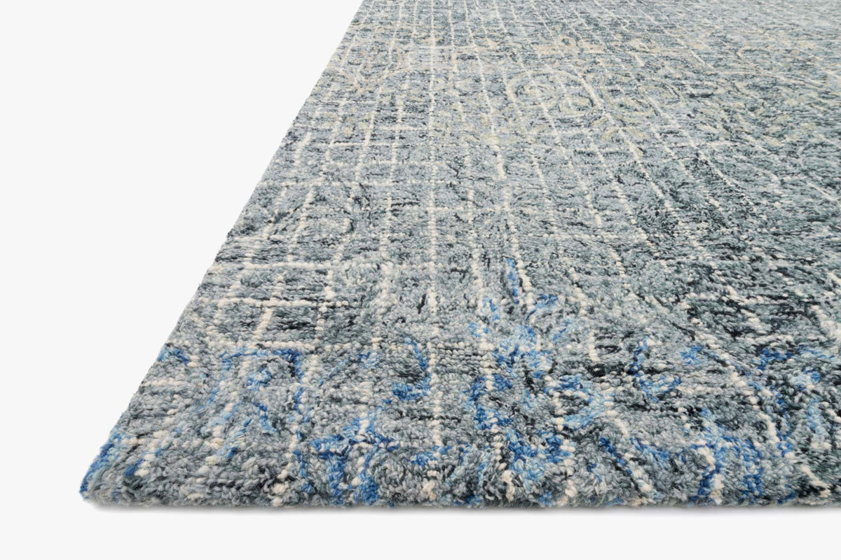 Transitional hooked rug corner, blue and dark ink with distressed abstract pattern texture