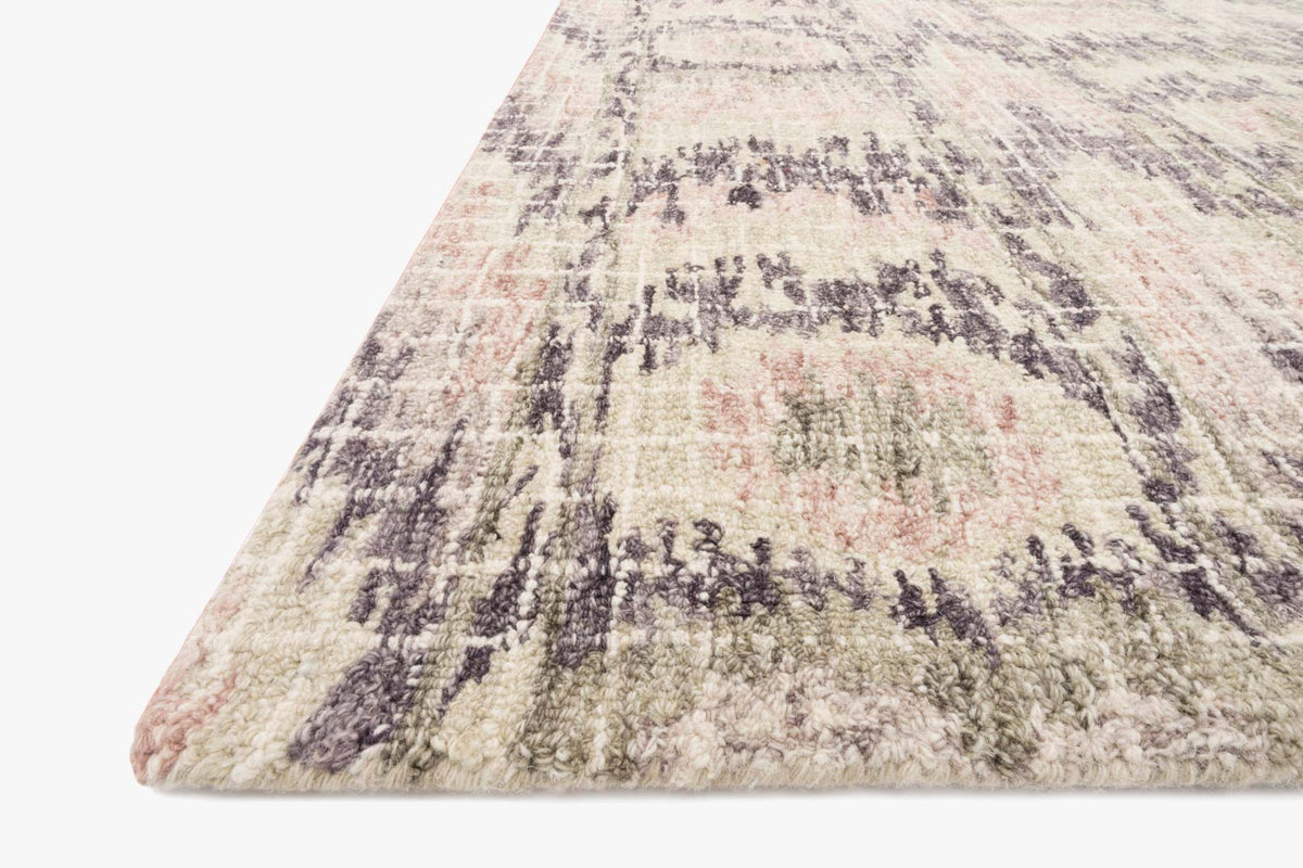 Corner view of blush transitional hooked rug with abstract dark motif and short pile