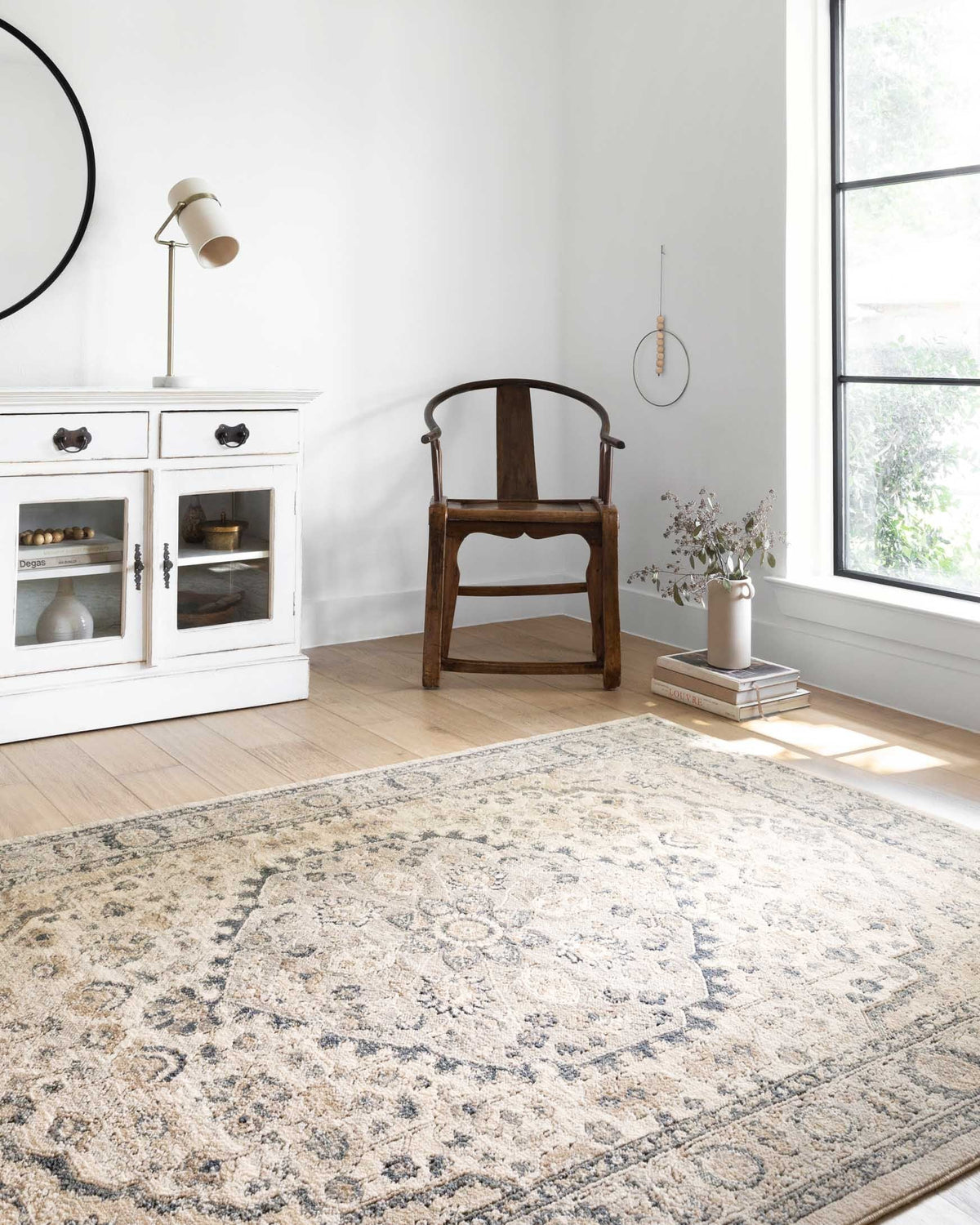 Rectangular area rug in natural and light gray with ornate medallion design