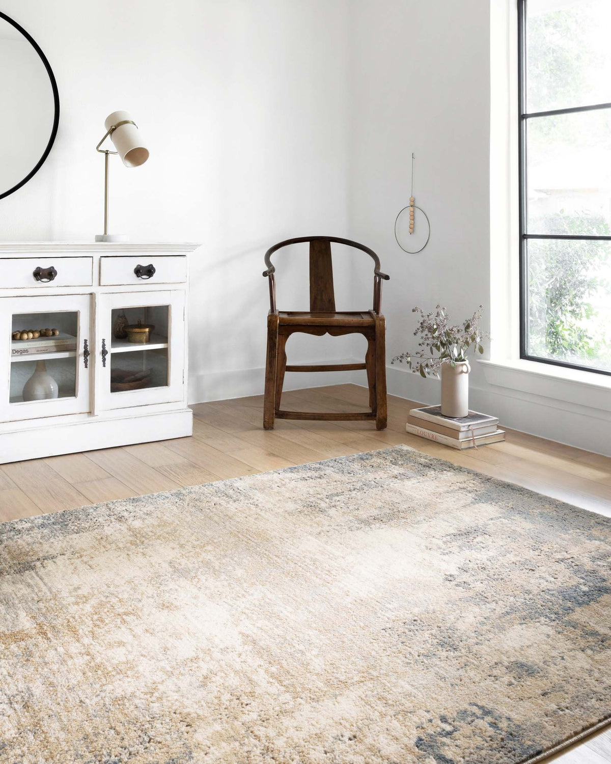 Ivory and mist area rug with distressed abstract design, shown in a living room setting.