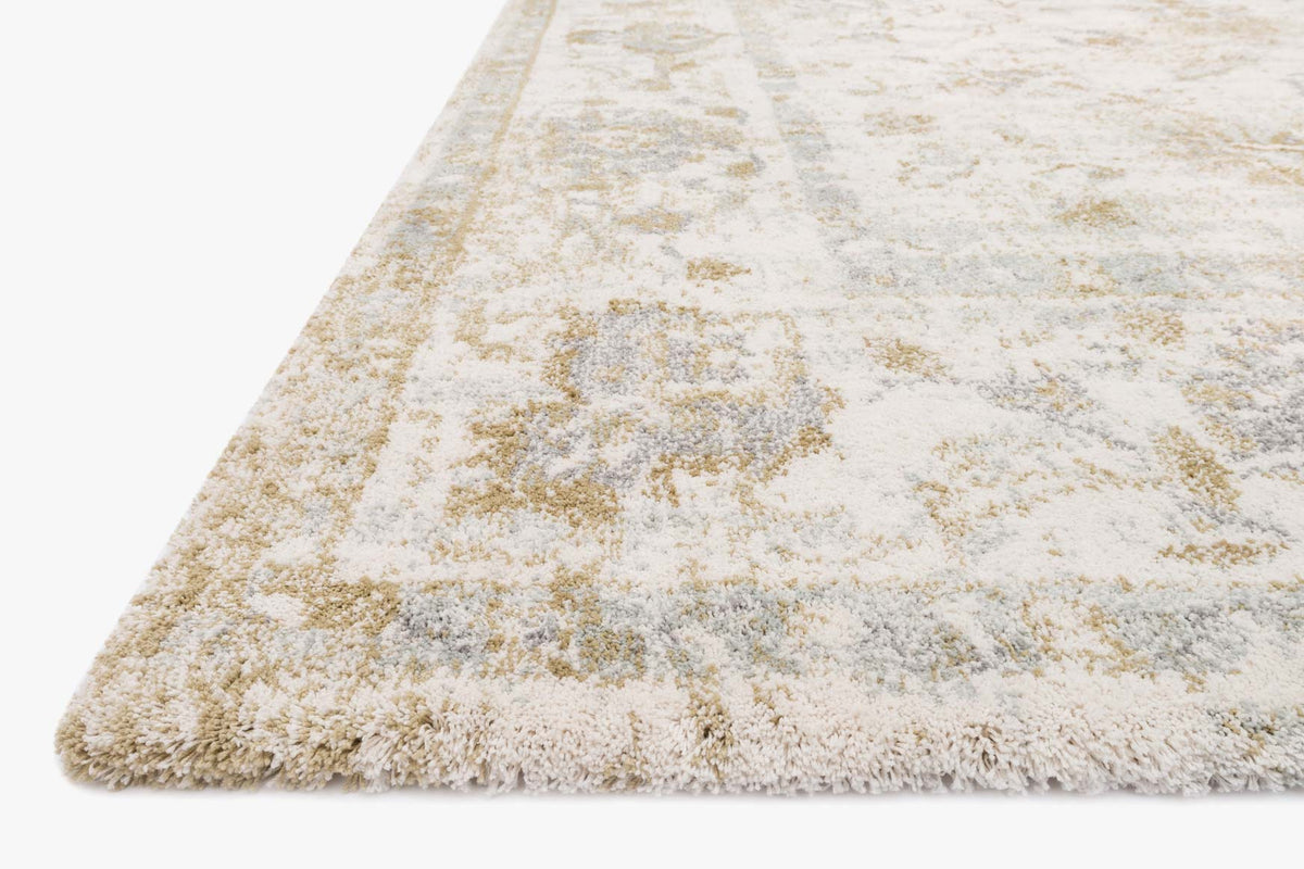 Ivory transitional power-loomed rug corner with distressed floral pattern and fringe