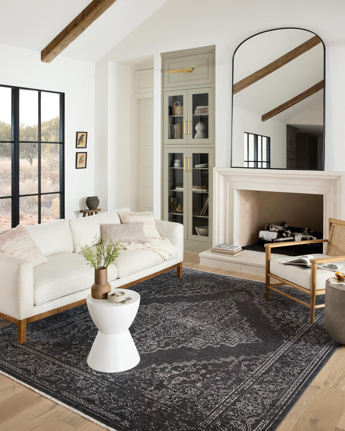 Charcoal and dove traditional power-loomed rug styled under furniture, showing bold geometric pattern.