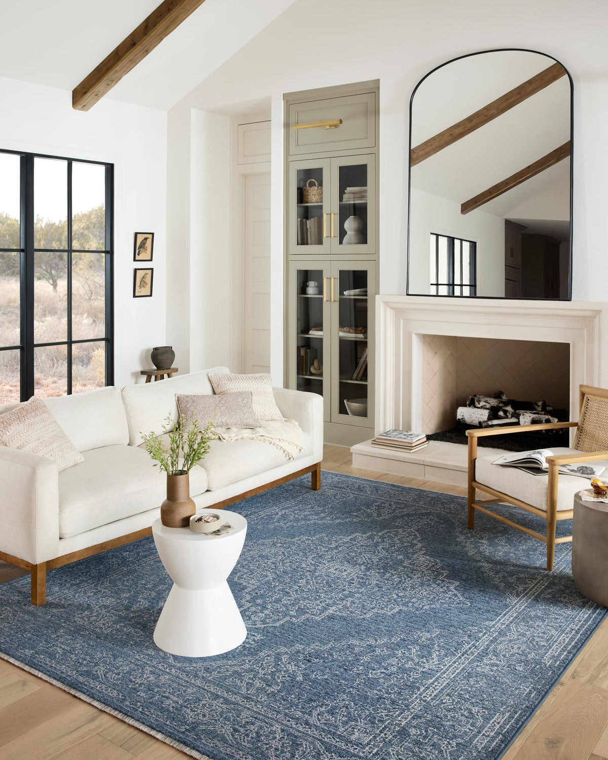 Denim blue rug with ornate pale pattern, shown laid in a living room