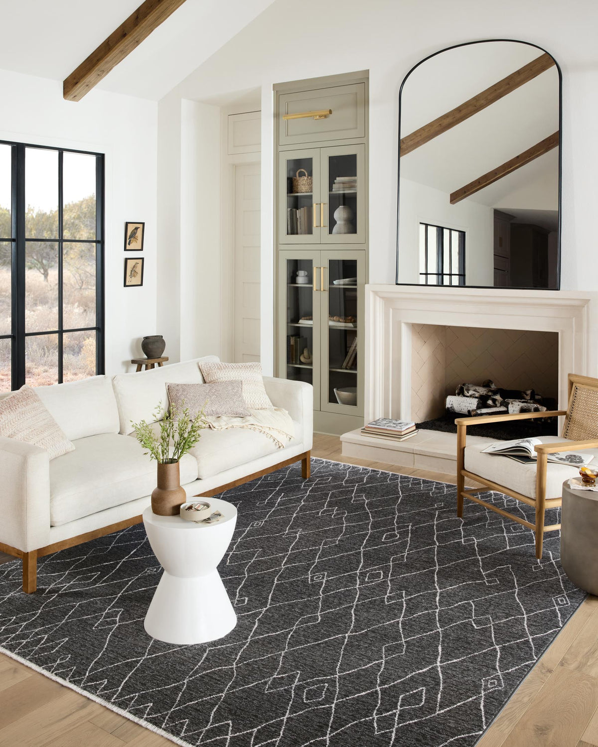 Charcoal geometric rug laid in living room, white outlined diamond motif