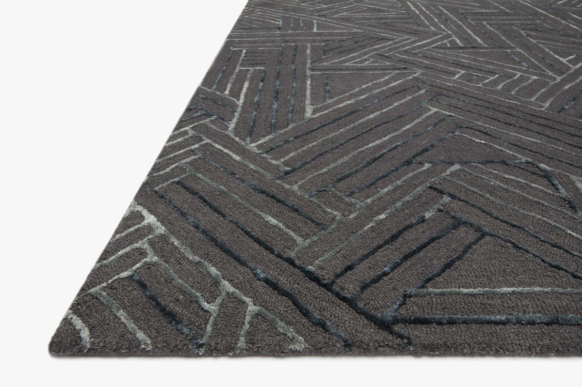 Hand-tufted rug corner with geometric pattern in dark graphite and muted ocean